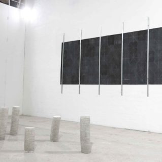Opera a muro di Cristina Treppo di carta vetrata piegata e barre in acciaio